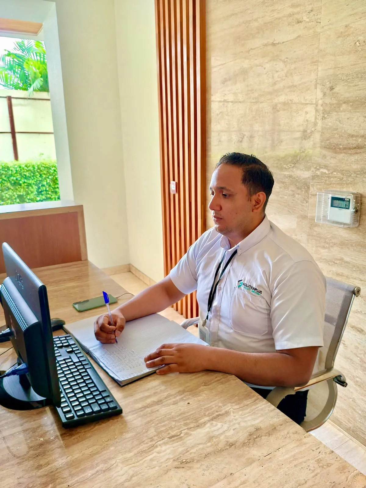 Auxiliar de conserjería de SolutionPlus registrando el ingreso de un visitante