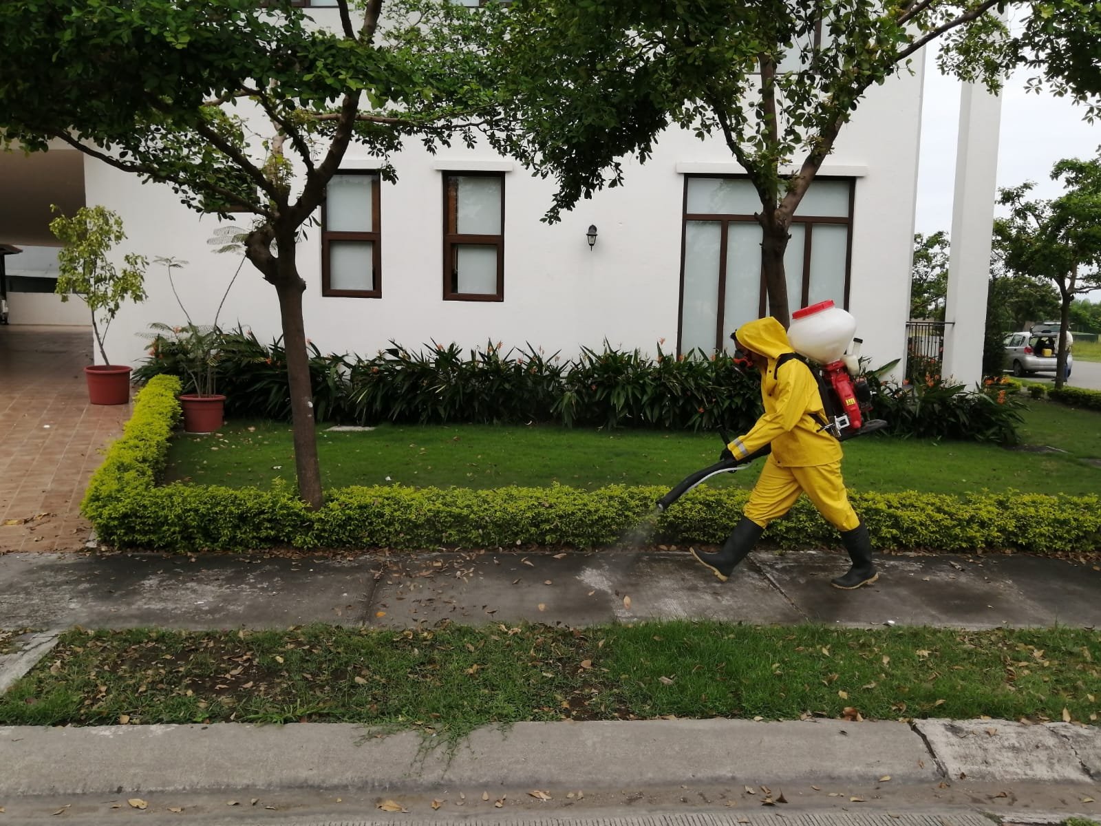 Técnico de SolutionPlus fumigando junto a una vivienda