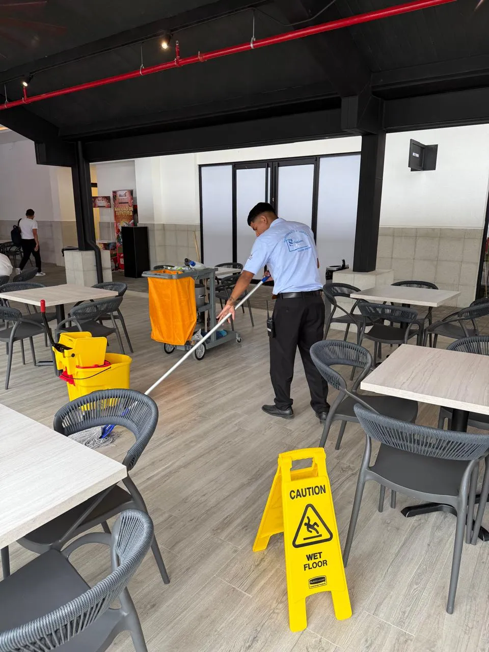 Personal de SolutionPlus limpiando el área de food court de un centro comercial
