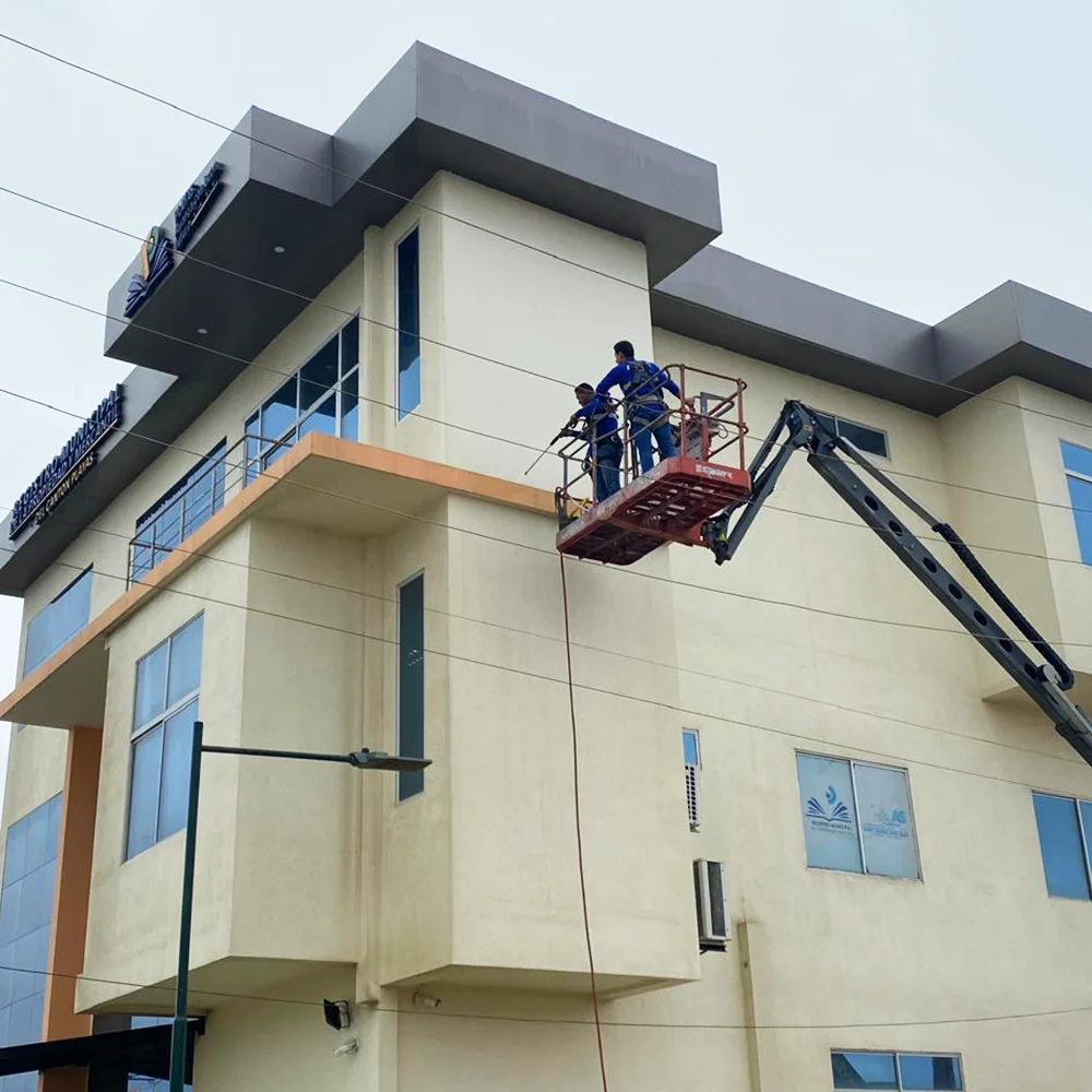 Limpieza de fachada de edificio empresarial desde brazo hidráulico
