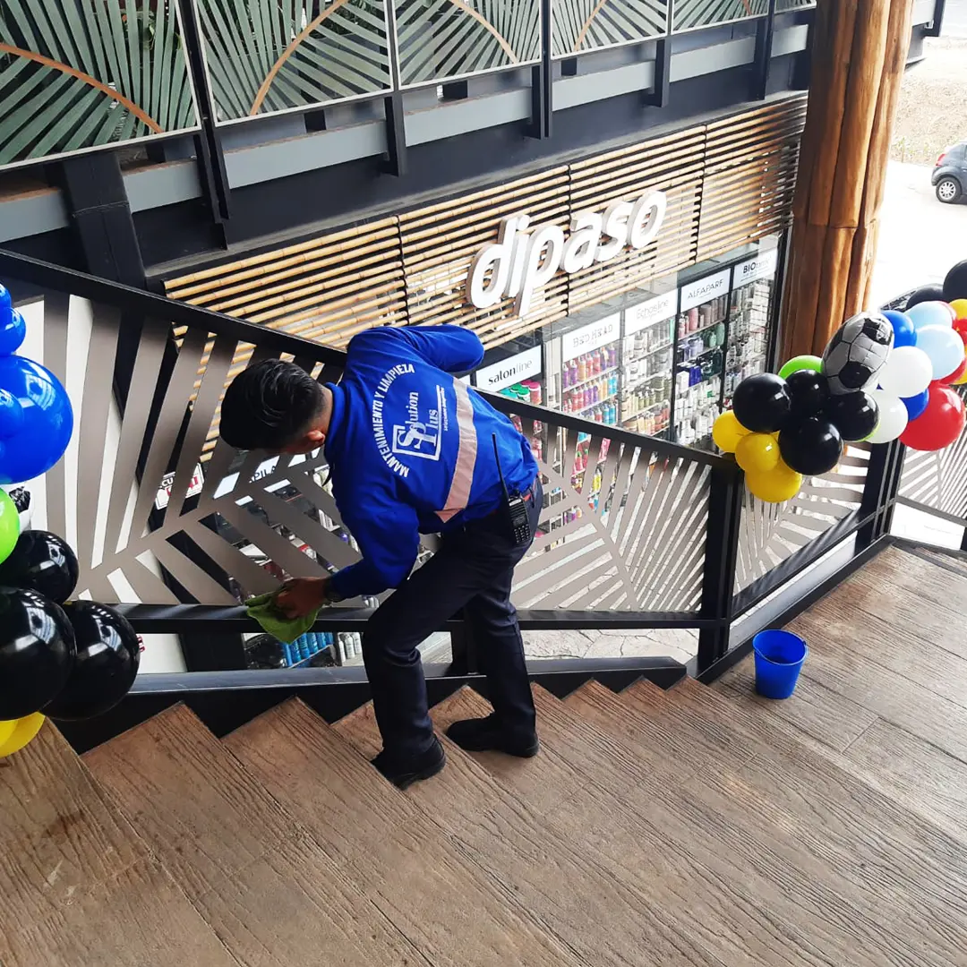 Personal de SolutionPlus limpiando pasamanos en centro comercial