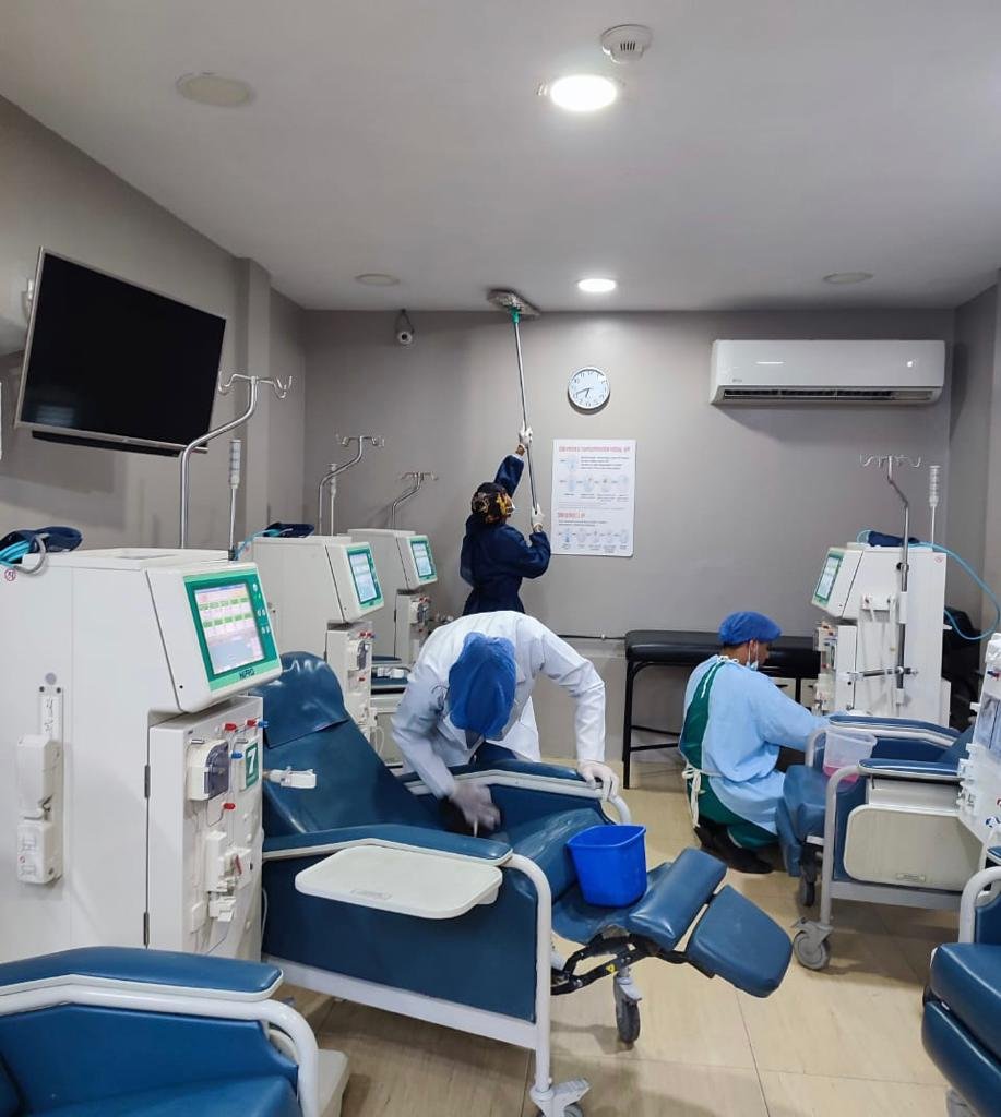 Personal de SolutionPlus limpiando techo de sala de diálisis en centro de salud