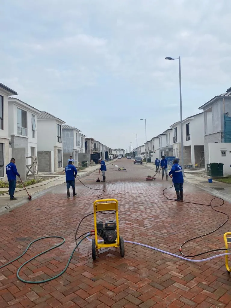 Cuadrilla de SolutionPlus hidrolavando la calle adoquinada de una urbanización