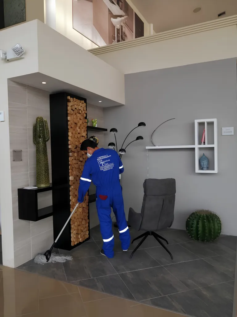 Trabajador de SolutionPlus trapeando el piso de un interior corporativo con mobiliario de diseño