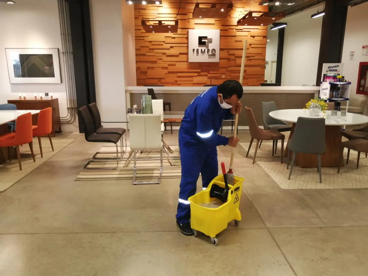 Trabajador de SolutionPlus trapeando la recepción de un showroom comercial