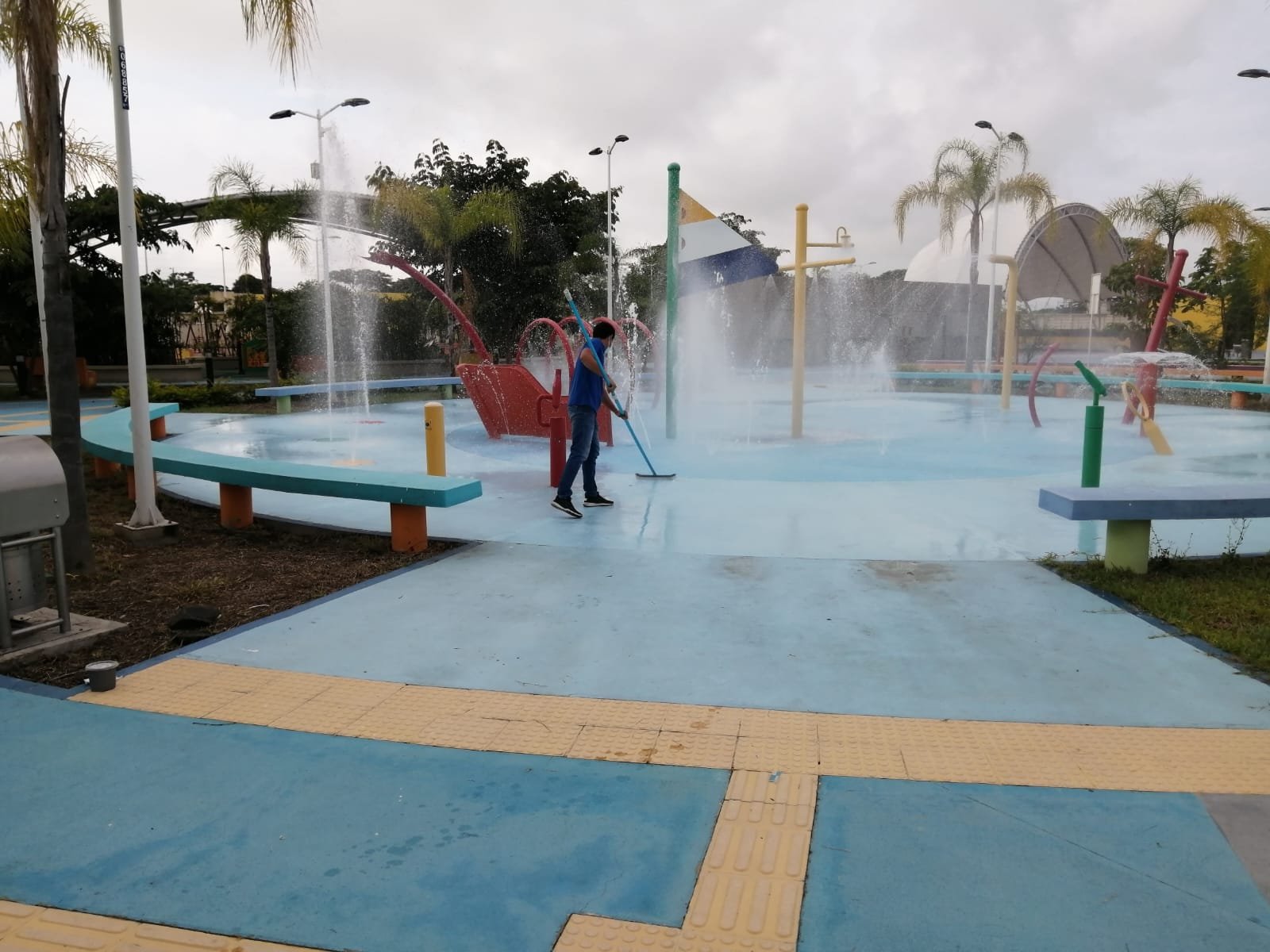 Trabajador de SolutionPlus limpiando la plataforma de un parque acuático de chorros